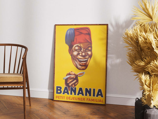 Vintage Banania plakat med smilende mand og ske – fransk retroreklame i gule og røde farver med teksten "Petit Déjeuner Familial".