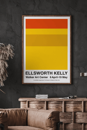 Walker Art Center plakat af Ellsworth Kelly med gule og orange farver i minimalistisk design, hængende over sofa i moderne hjem.