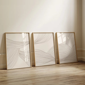 Moderne billedvæg med tre neutrale plakater i beige toner og abstrakte linjer