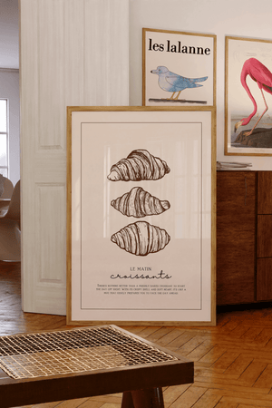 Croissant plakat med tre håndtegnede croissanter i brun ramme – perfekt som køkkenplakat med fransk caféstemning.