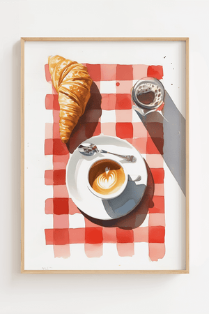 Plakat med croissant, cappuccino og rødternet dug i lys træramme – hyggelig fransk caféstemning til køkkenet.

