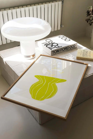 Plakat med grøn organisk form og fine linjer på lys baggrund i moderne indretning