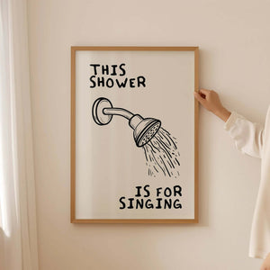 Humoristisk badeværelsesplakat med teksten "This Shower Is For Singing" i moderne typografi – perfekt til sangglade hjem