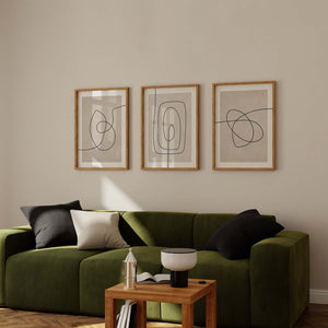 Moderne billedvæg med tre abstrakte line art plakater i beige og sort