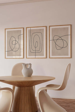 Moderne billedvæg med tre abstrakte line art plakater i beige og sort