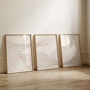 Moderne billedvæg med tre neutrale plakater i beige toner og abstrakte linjer