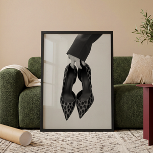 Sort hvid plakat med elegante stiletter holdt i hånden