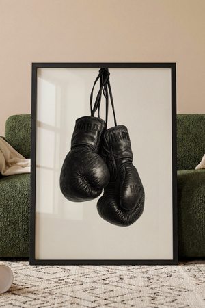 Sort hvid plakat med vintage boksehandsker hængende i snore
