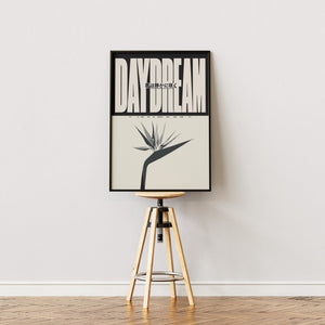 Daydream plakat med stor beige typografi, japansk tekst og stiliseret blomst i egetræsramme på staffeli