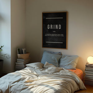 Grind Definition plakat med hvid typografi på mørk baggrund i egetræsramme over seng