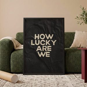 How Lucky Are We plakat i egetræsramme ved sofa