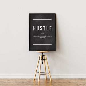 Hustle plakat med sort baggrund og hvid typografi og definition i egetræsramme på staffeli