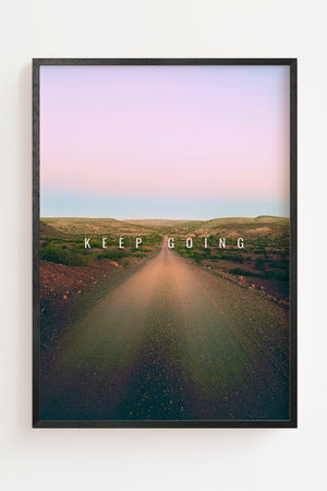 Keep Going plakat med vej gennem tørt landskab i lyserøde og blå toner, sort ramme