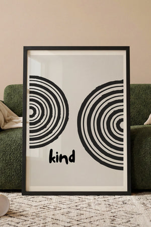 Kind plakat med koncentriske cirkler i sort og hvid i egetræsramme ved sofa