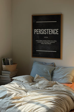 Persistence definition plakat med typografi i hvidt på mørk baggrund i egetræsramme over seng