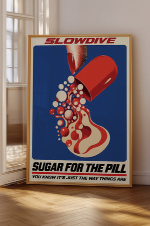 Slowdive plakat med rød kapsel og grafiske former på blå baggrund i egetræsramme på gulv ved vindue
