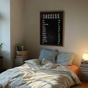 Success kontrolpanel plakat med hvid typografi og grønne knapper på sort baggrund i egetræsramme over seng